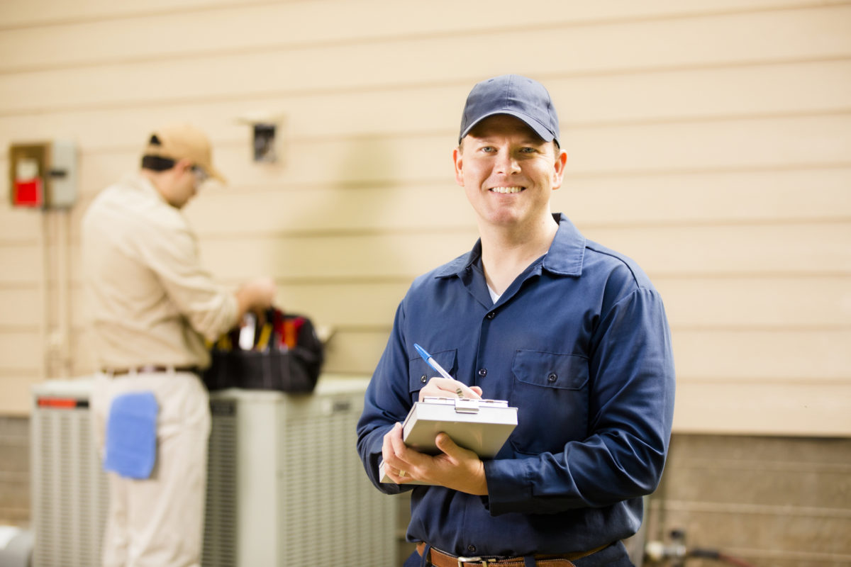 Elite Air technicians servicing an outdoor air conditioning unit