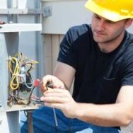 HVAC technician testing electrical components on a heating unit