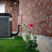 Newly installed outdoor heat pump beside a brick home